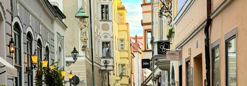 Enge Altstadtgasse mit Laternen, Erkern und Ladenschildern