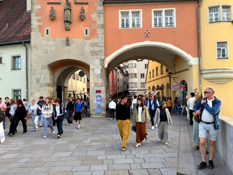 Altes Stadttor in Regensburg mit Passanten auf dem Platz davor
