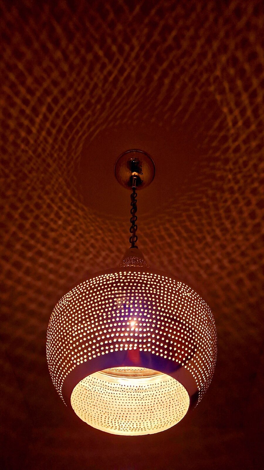 Lichtspiel einer Kupferlampe an der Decke