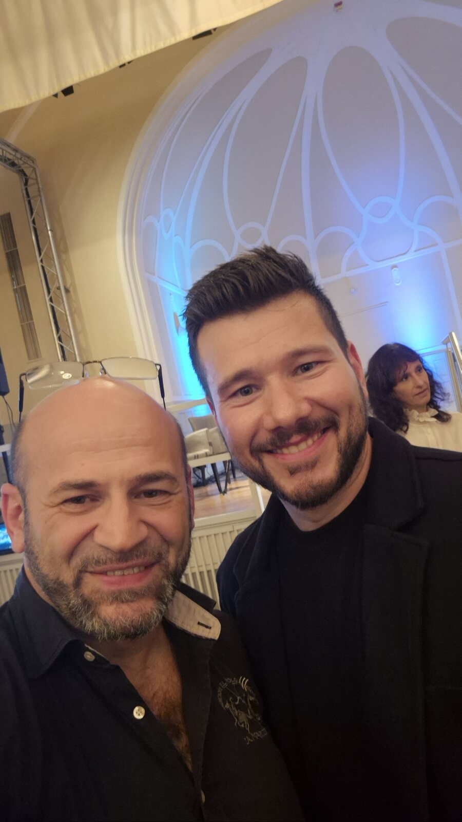 Selfie von Suat Akyol und Deniz Ates beim Abendempfang im Steeler Stadtgarten, im Hintergrund das große Rundbogenfenster in blauem Licht